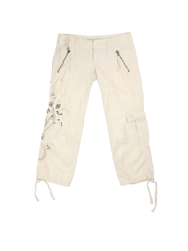 Y2K Guess Capri Trousers in white colourway with cargo pockets/ties and embroided/beaded detaling on right leg.