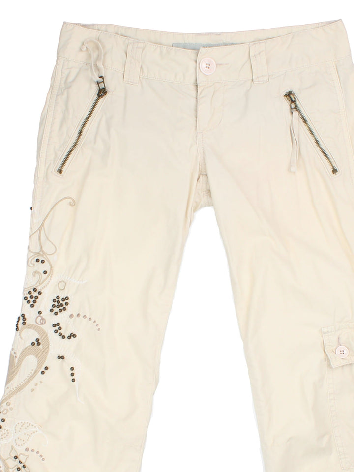 Y2K Guess Capri Trousers in white colourway with cargo pockets/ties and embroided/beaded detaling on right leg.