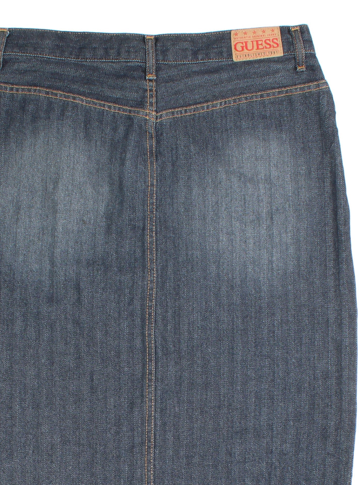 Y2K Guess Denim Skirt in blue colourway. Button/zip fastening, with front slit detailing and leather branded patch.