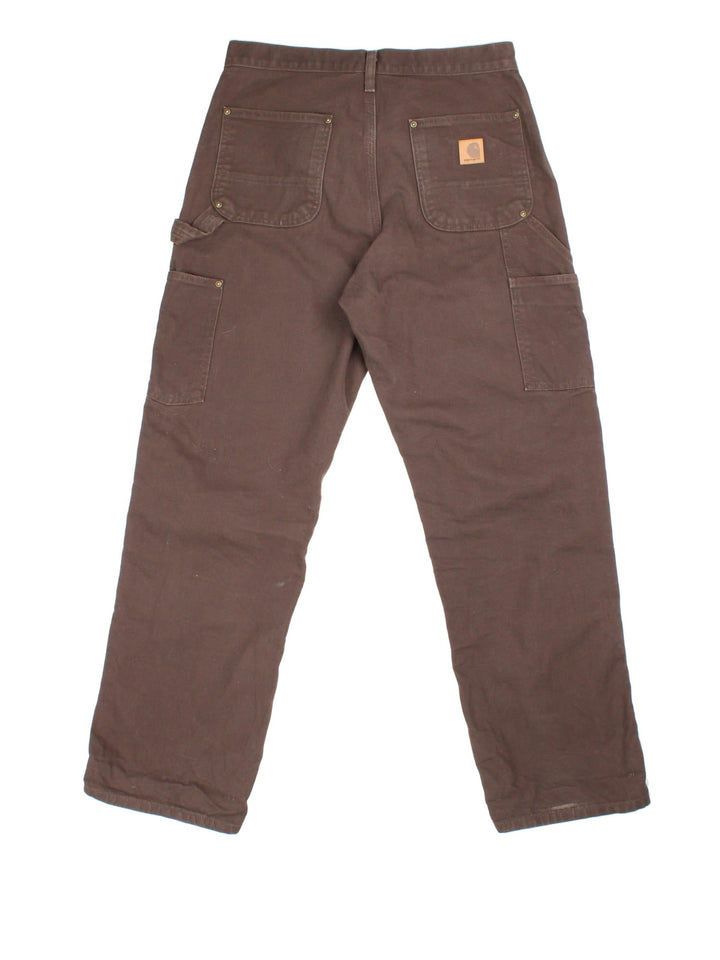 Carhartt Double Knee Jeans in a brown colourway, with multiple pockets and leather logo on the back pocket.