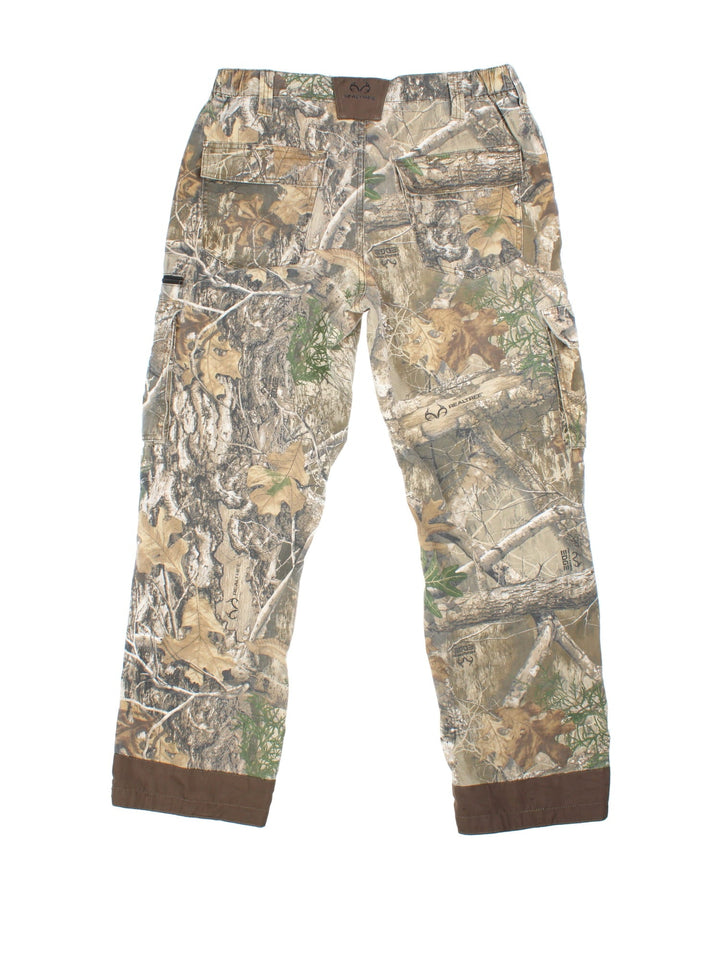 Vintage Real Tree Camo Cargo Trousers in brown and green colourway with multiple utility pockets, brown cuffs on the back, and the logo embroidered on the back.