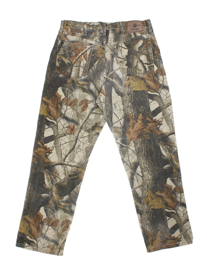 Wrangler Real Tree Camo Jeans in green and brown patterned colourway with multiple pockets, double knee features, and has the logo embroidered on the back.