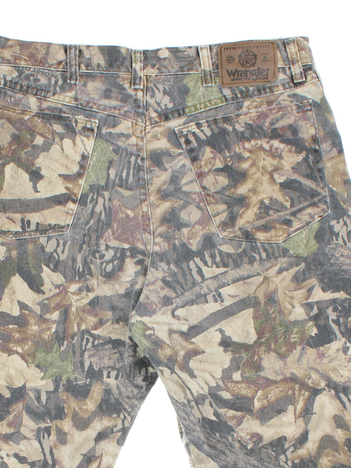 Wrangler Mossy Oak Forest Camo Jeans in green and brown colourway with multiple pockets and the logo embroidered on the back.