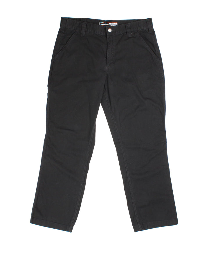 Carhartt Trousers in black colourway. Zip fly fastening with multiple pockets and embroidered patch branding.