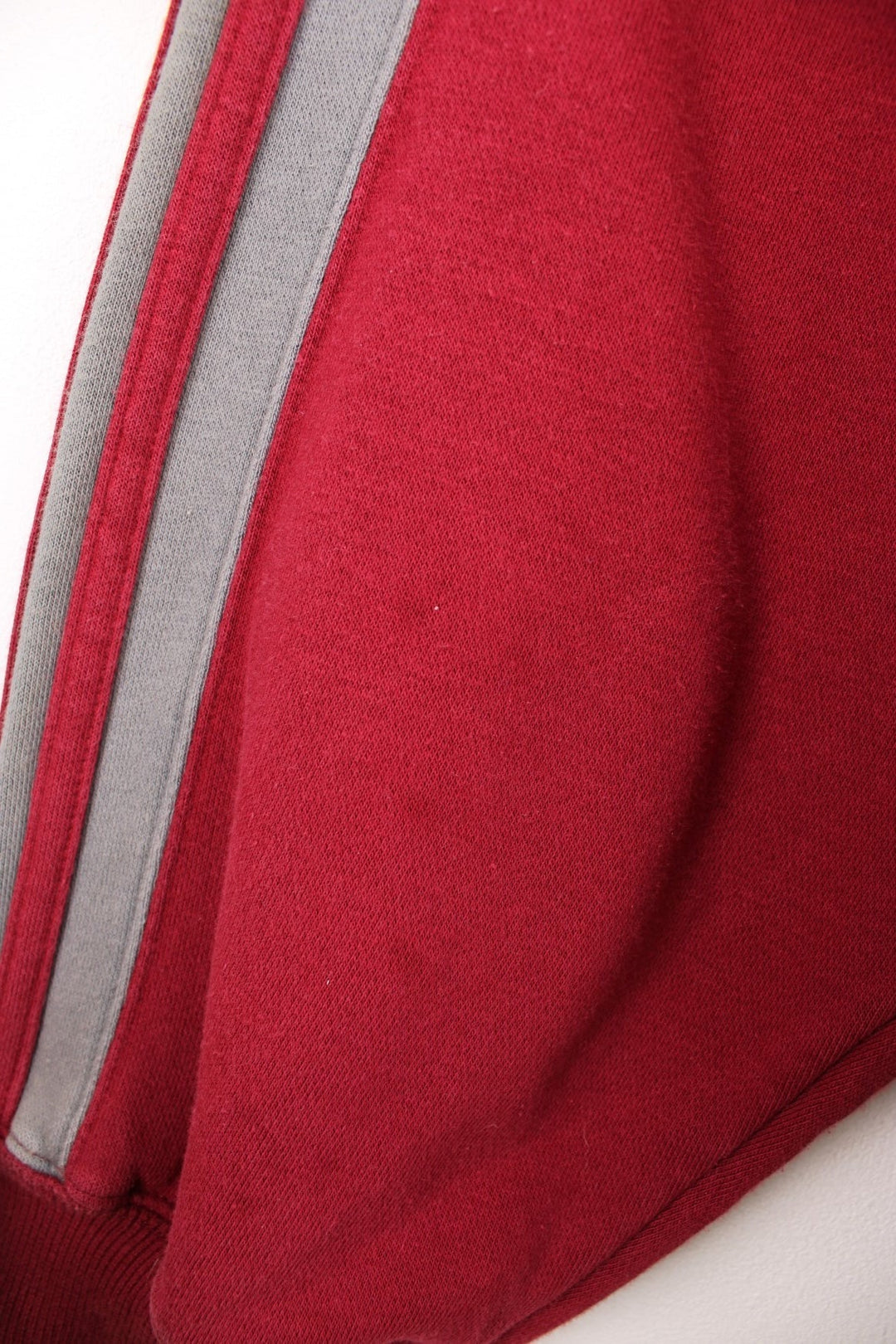 Adidas Sweatshirt in a red and grey colourway with the iconic three stripes going down the arms, and has the logo embroidered on the chest. 