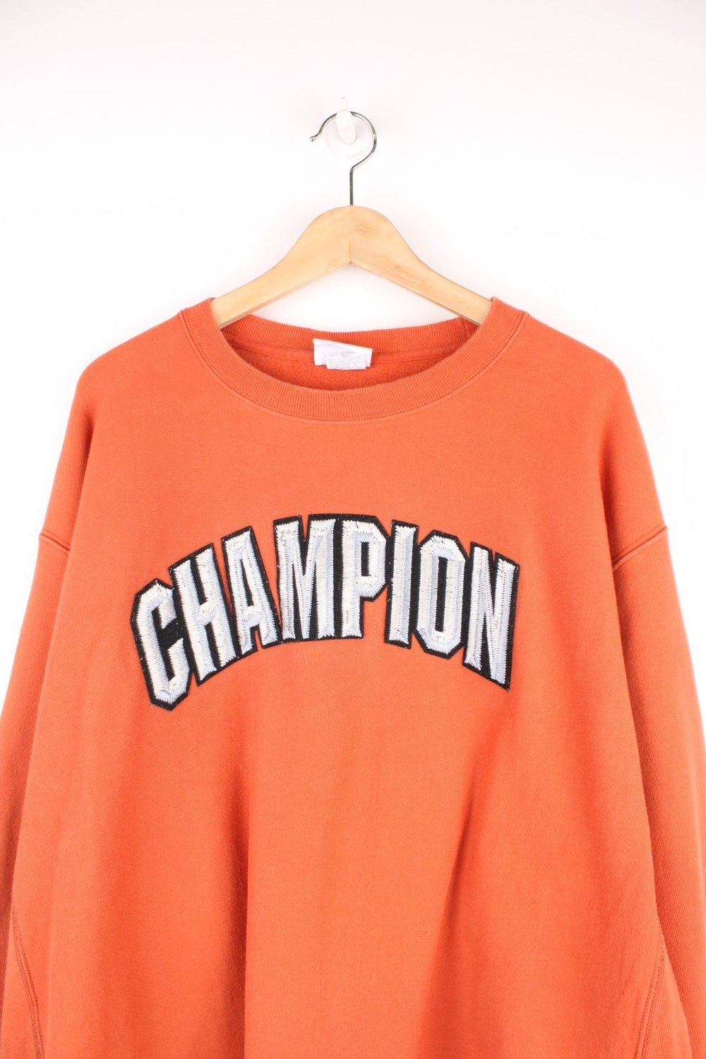 Champion Reverse Weave Sweatshirt in an orange colourway with the spell out logo embroidered across the chest in a metallic style. 