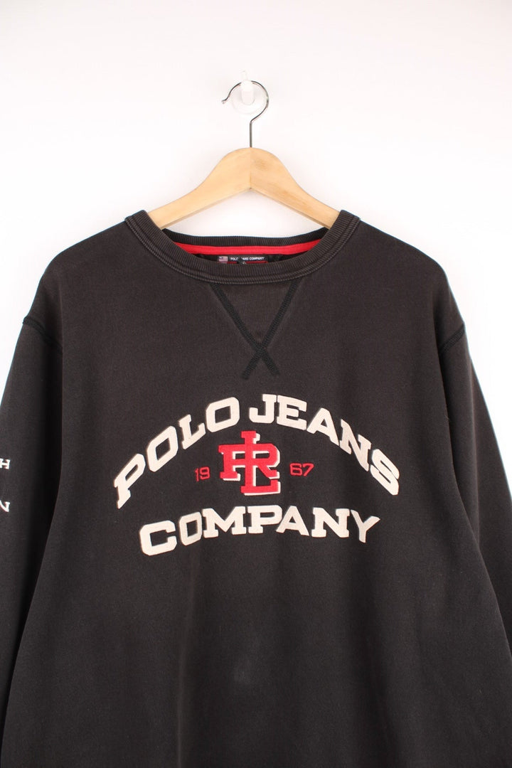 Ralph Lauren Polo Jeans Company Sweatshirt in a black colourway with the spell out logo embroidered across the front and on the right sleeve. 