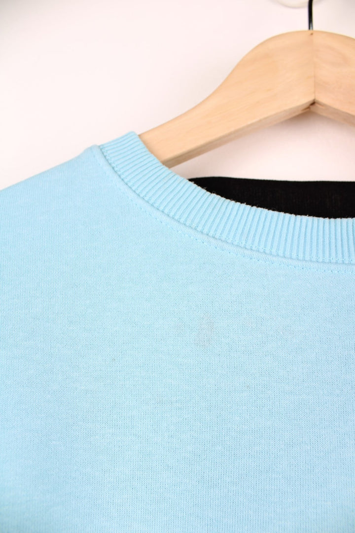 CP Company Sweatshirt in a baby blue colourway, plain crewneck with the google and pocket on the left sleeve.