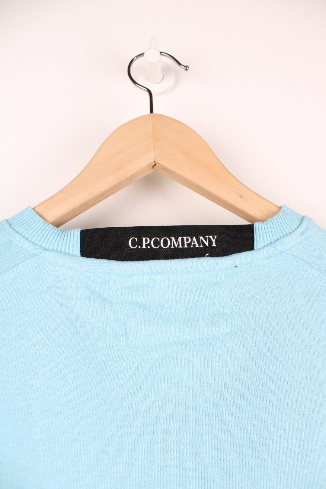 CP Company Sweatshirt in a baby blue colourway, plain crewneck with the google and pocket on the left sleeve.