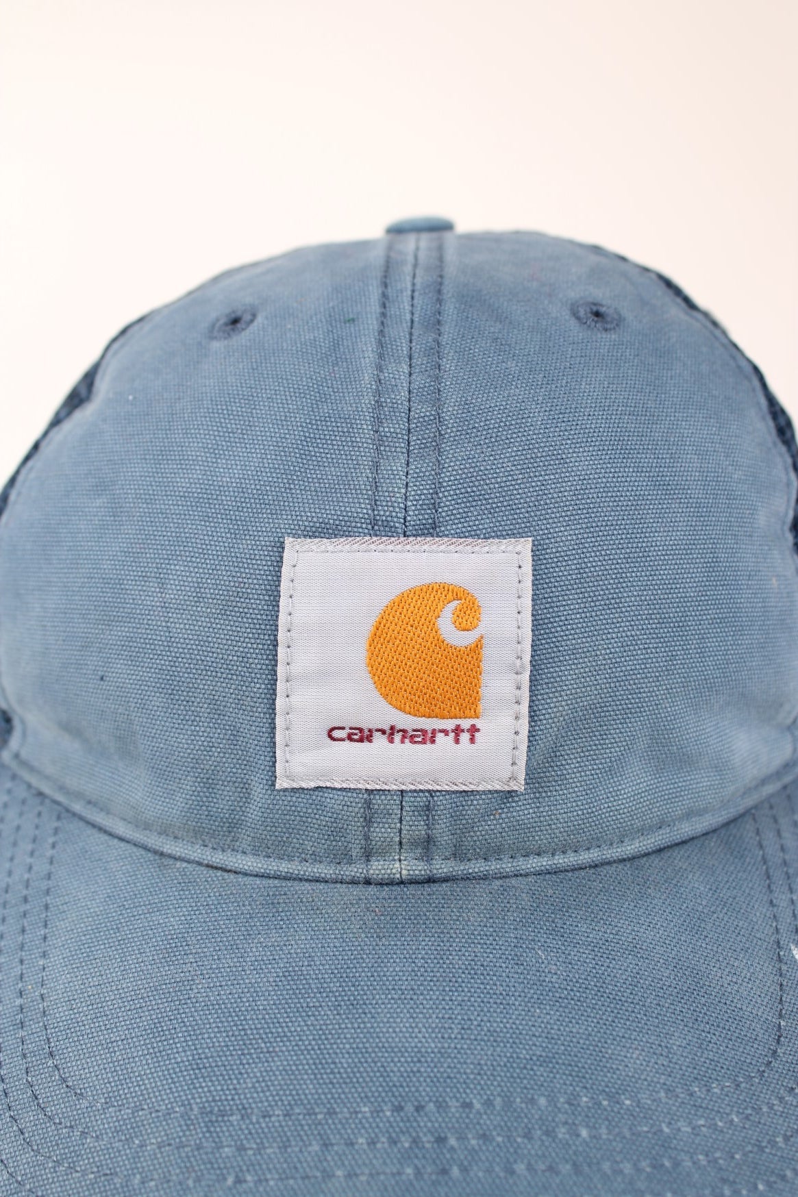 Carhartt Mesh Trucker Cap in a blue colourway with the logo embroidered on the front and has a adjustable strap on the back.