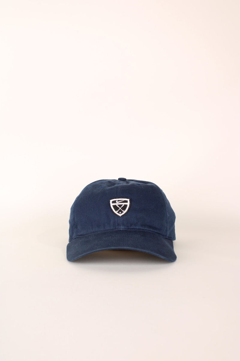 Nike Golf Cap in a navy blue colourway with the logo embroidered on the front and back, has a adjustable velcro strap.