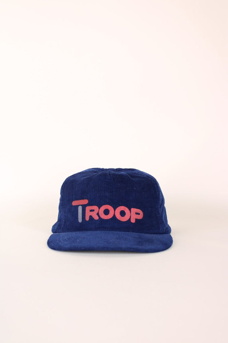 Vintage Troop Corduroy Trucker Hat in a navy blue colourway with the spell out printed on the front, and has a adjustable strap. 