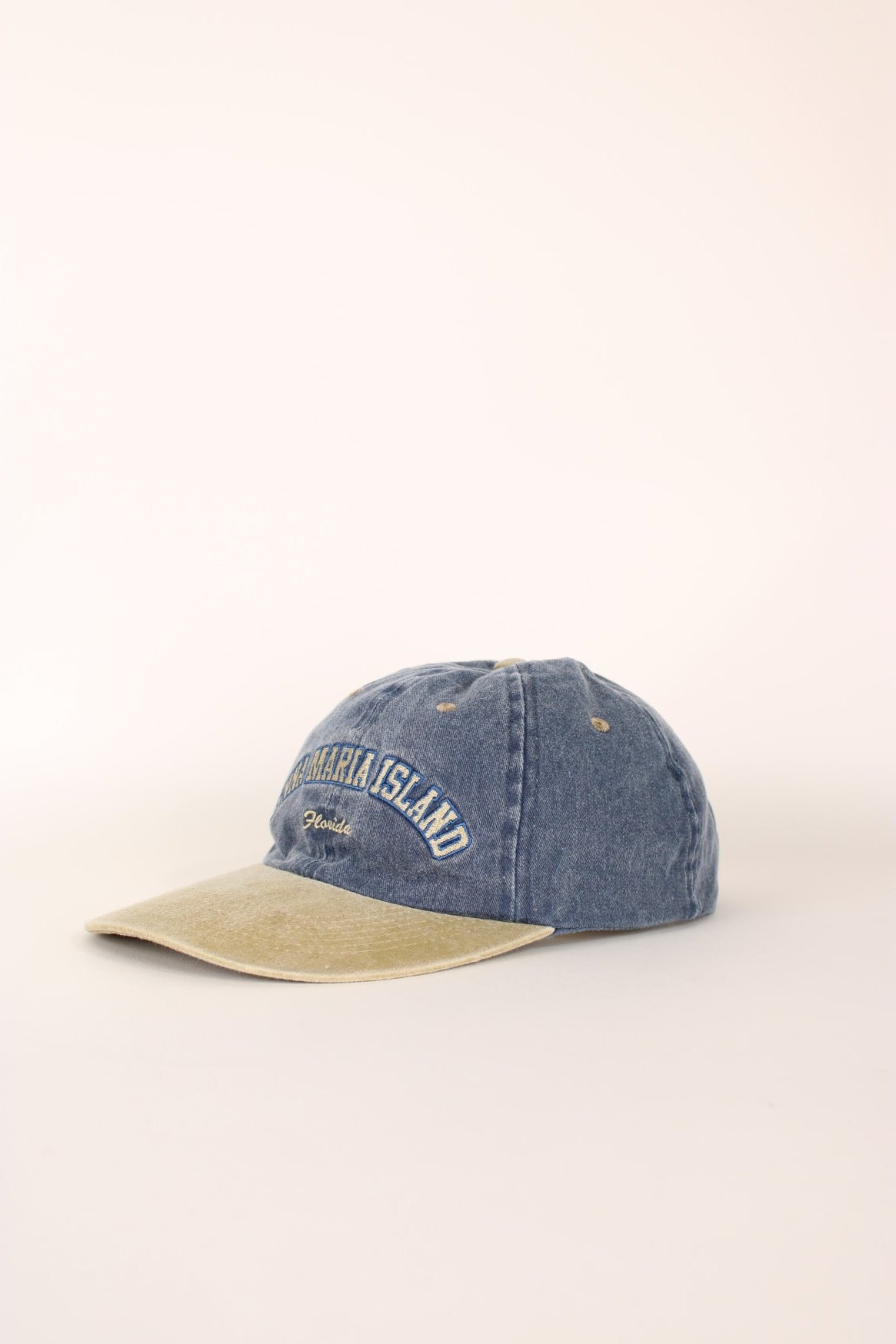 Anna Maria Island Florida Cap in a faded blue and tanned colourway with the spell out logo embroidered on the front, and has a adjustable velcro strap.