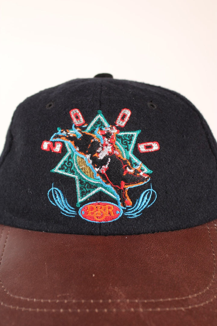 Vintage Professional Bull Riding Year 2000 Cap in a black and brown colourway with the logo embroidered on the front and Bud Light sponsor on the back, has an adjustable strap.