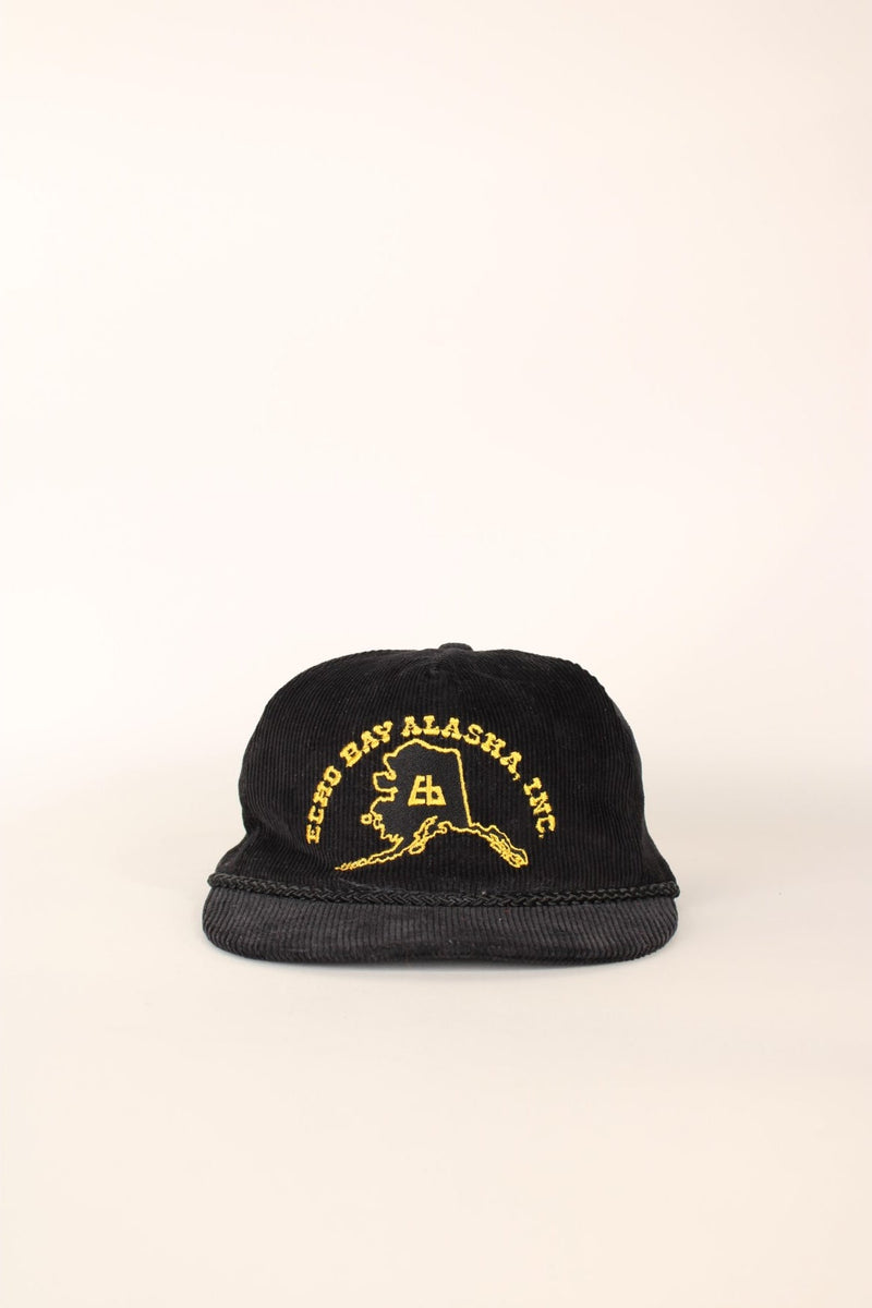 Vintage Echo Bay Alaska Inc. Corduroy Trucker Hat in a black and yellow colourway, has an adjustable strap.