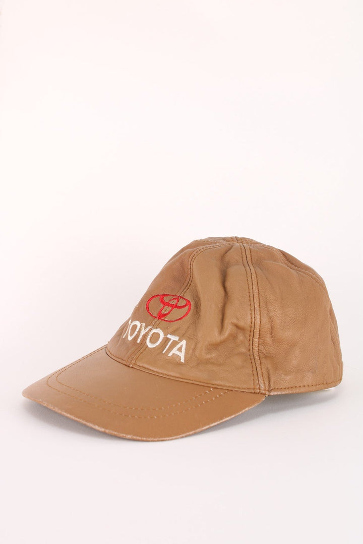 Vintage Toyota Leather Cap in a brown colourway with the logo embroidered on the front, and has an adjustable velcor strap.