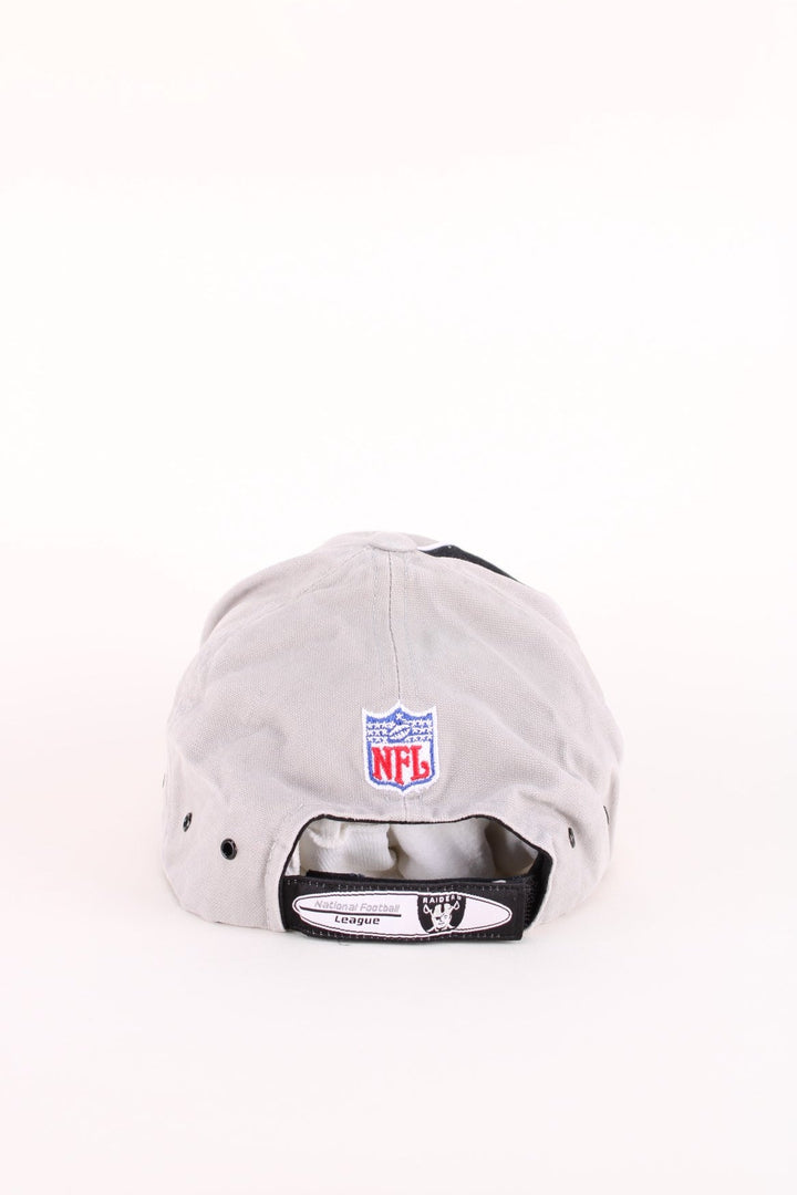 Oakland Raiders NFL Cap in a grey and black colourway with the team logos and spell out embroidered on the hat, and has an adjustable velcro strap.