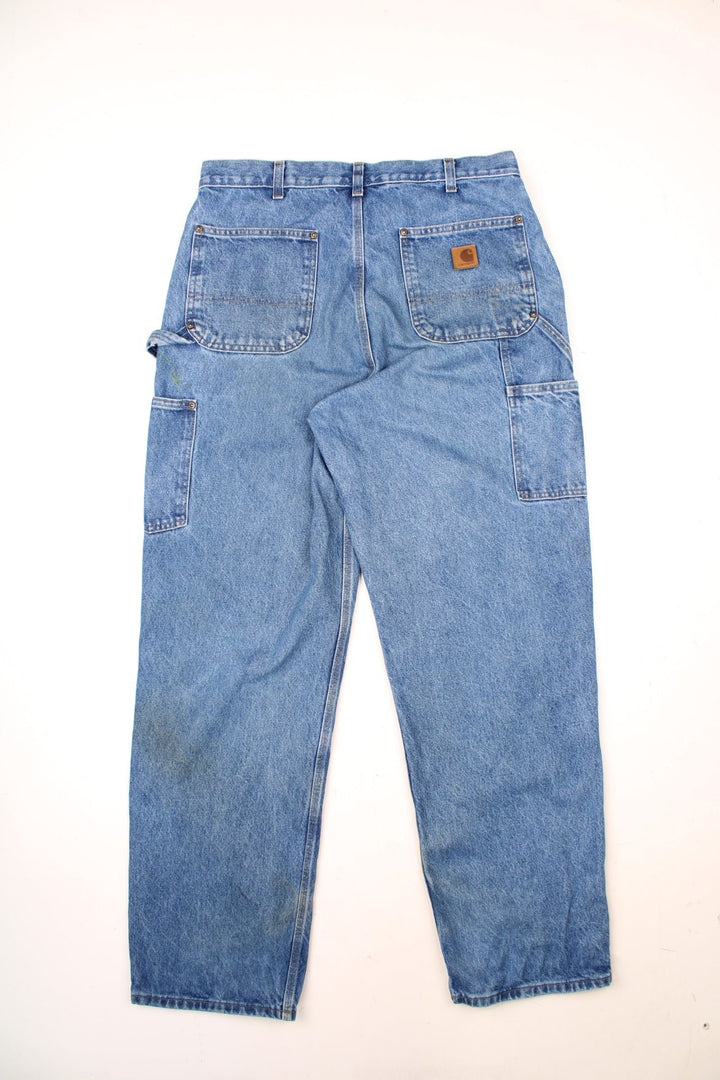 Carhartt Double Knee Jeans in a blue colourway with multiple pockets and the logo embroidered on the back.