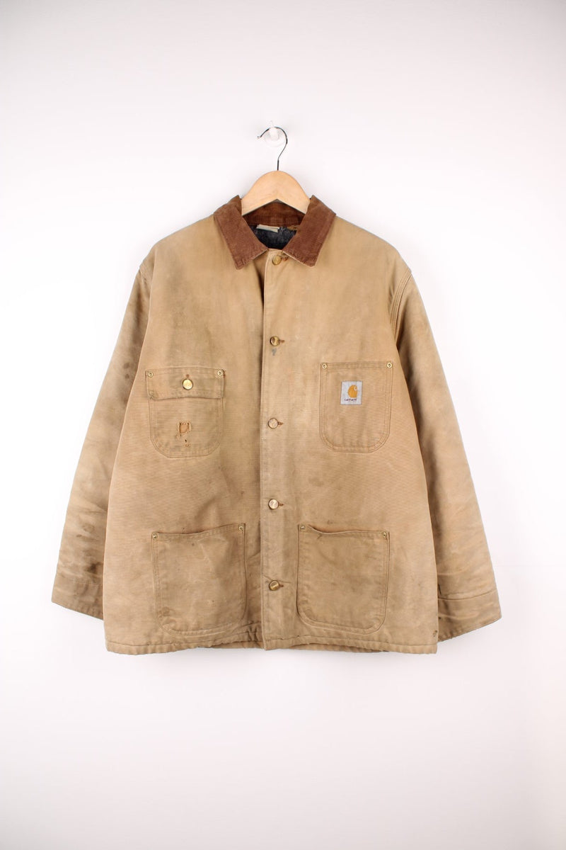 Carhartt Chore Jacket in a tanned colourway with a brown corduroy collar, button up with multiple pockets, blanket lining, and has the logo embroidered on the front. 