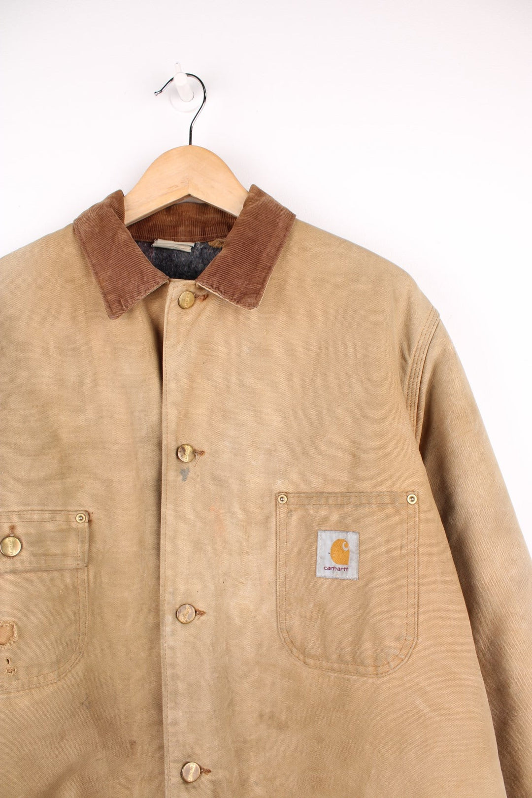 Carhartt Chore Jacket in a tanned colourway with a brown corduroy collar, button up with multiple pockets, blanket lining, and has the logo embroidered on the front. 