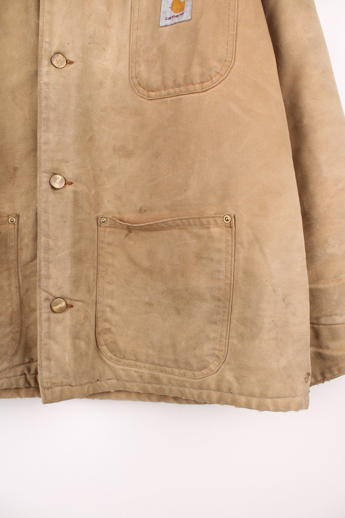 Carhartt Chore Jacket in a tanned colourway with a brown corduroy collar, button up with multiple pockets, blanket lining, and has the logo embroidered on the front. 