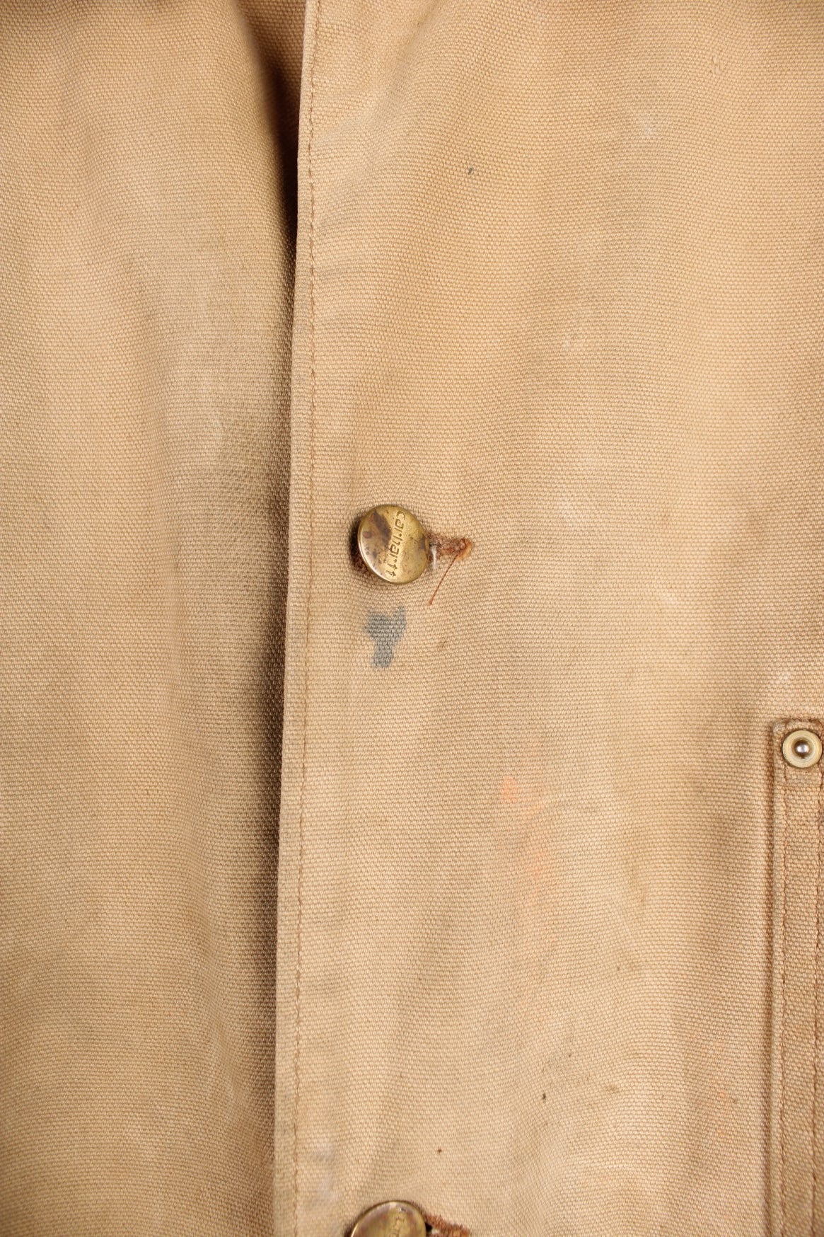 Carhartt Chore Jacket in a tanned colourway with a brown corduroy collar, button up with multiple pockets, blanket lining, and has the logo embroidered on the front. 