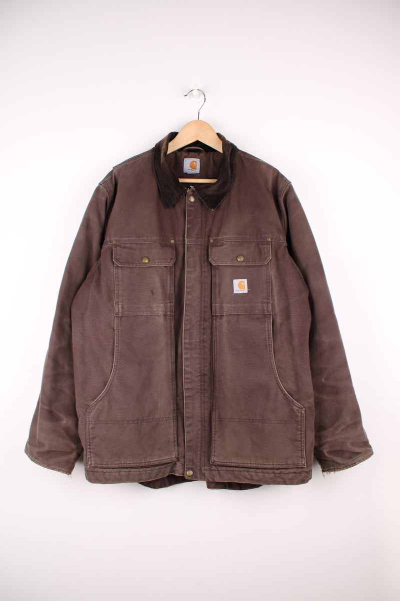 Carhartt Workwear Jacket in a brown colourway with a corduroy collar, zip up with multiple pockets, quilted lining, and has the logo embroidered on the front. 