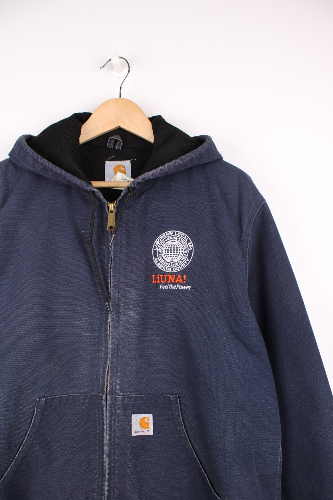 Carhartt Active Jacket in a blue colourway, zip up with side pockets, hooded, and has the logo embroidered on the front along side &