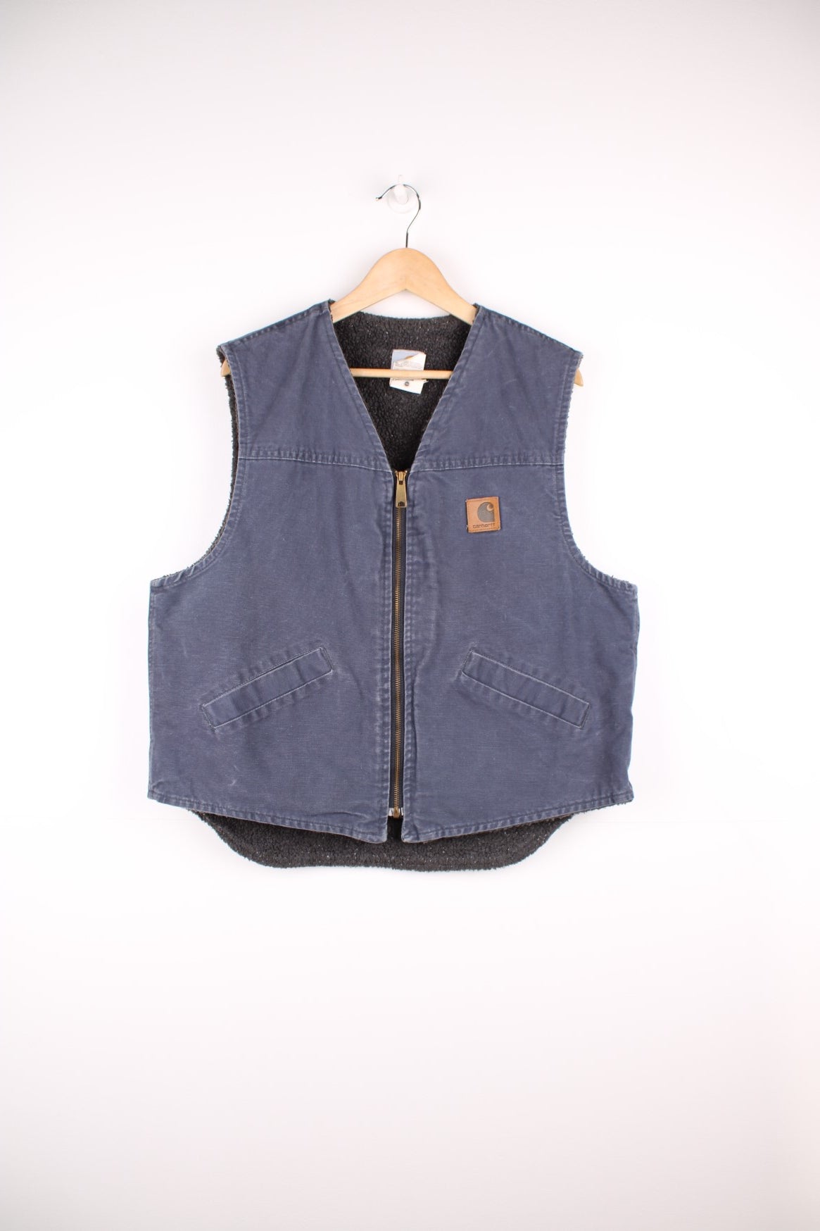 Carhartt Gilet in a blue colourway, zip up with side pockets, sherpa lining, and has the logo embroidered on the front.