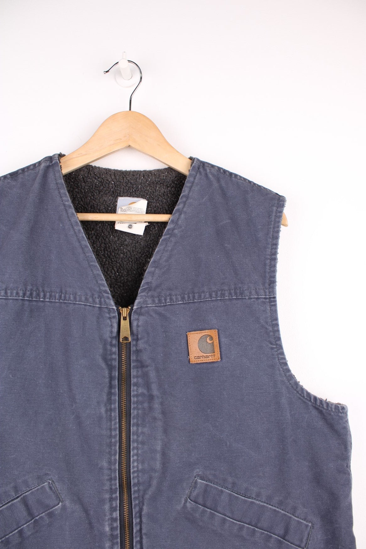 Carhartt Gilet in a blue colourway, zip up with side pockets, sherpa lining, and has the logo embroidered on the front.