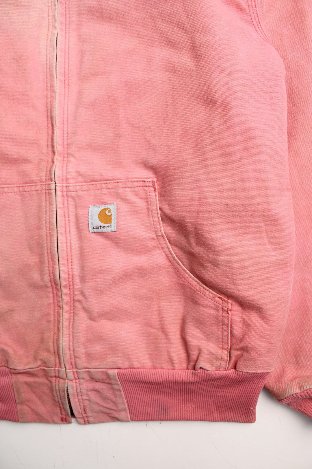 Carhartt Active Jacket in a pink colourway. Zips up and has side pockets, hooded, and has the logos embroidered on the front.