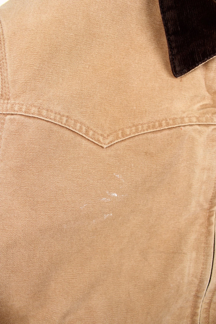 Carhartt Santa Fe Jacket in a tan colourway with a brown corduroy collar. Zips up and has side pockets, and the logo embroidered on the front.