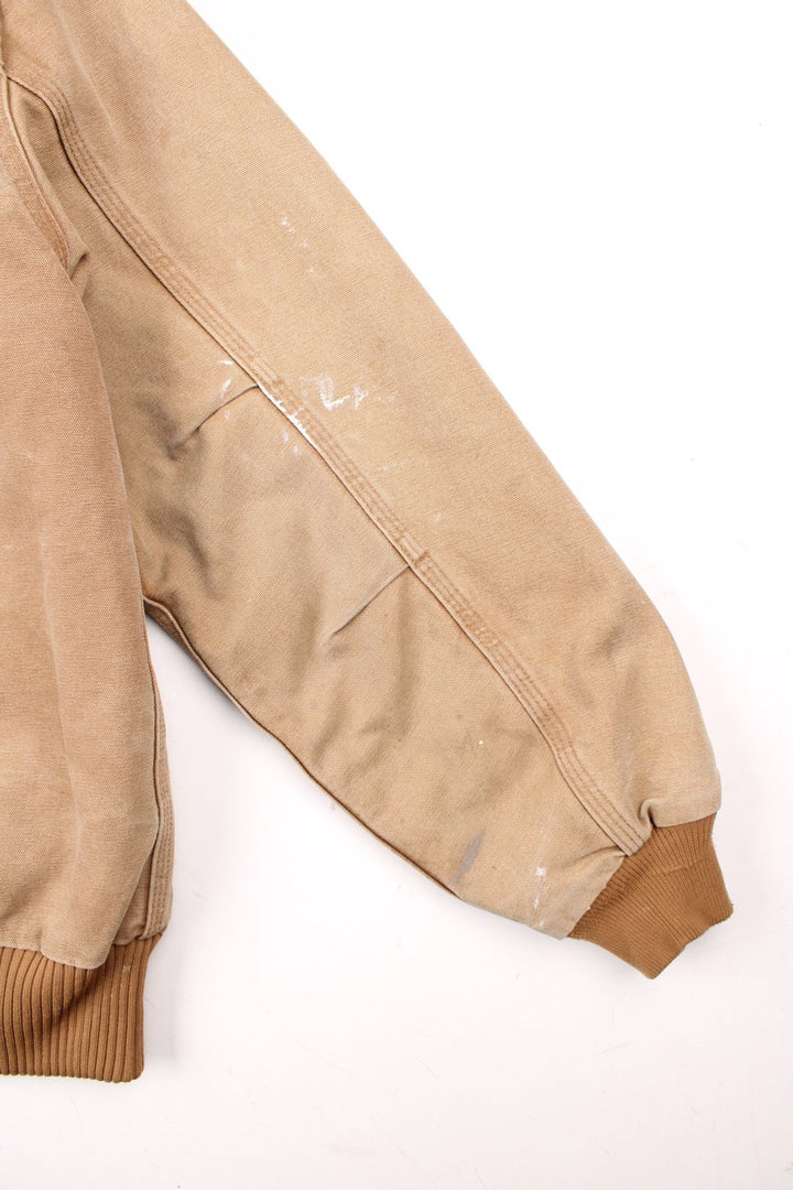 Carhartt Santa Fe Jacket in a tan colourway with a brown corduroy collar. Zips up and has side pockets, and the logo embroidered on the front.