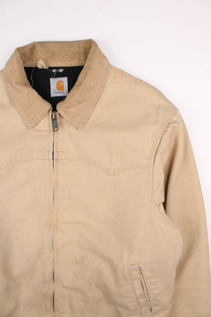 Carhartt Santa Fe Jacket in a tan colourway. Zips up and has side pockets, corduroy collar, and has the logo embroidered on the front.