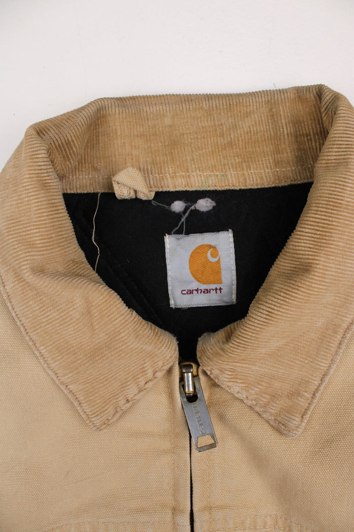 Carhartt Santa Fe Jacket in a tan colourway. Zips up and has side pockets, corduroy collar, and has the logo embroidered on the front.