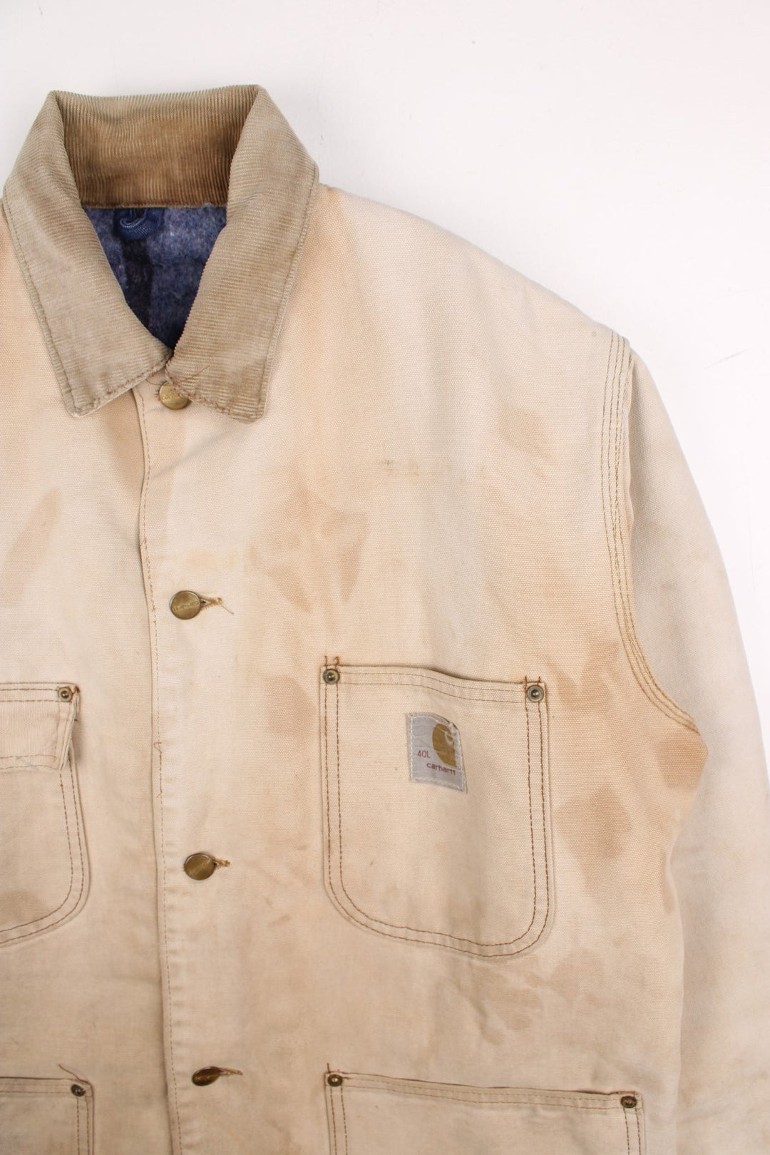 Vintage 70's Carhartt Distressed Chore Jacket in a tan colourway. Buttons up and has multiple pockets, blanket lining, corduroy collar, and has the logo embroidered on the front.