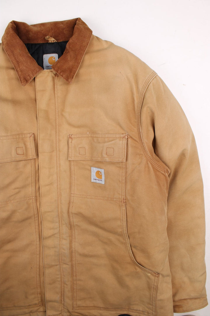 Carhartt Arctic Jacket in a tan colourway. Zips up and has multiple pockets, corduroy collar, insulated with a quilted lining, and has the logo embroidered on the front.