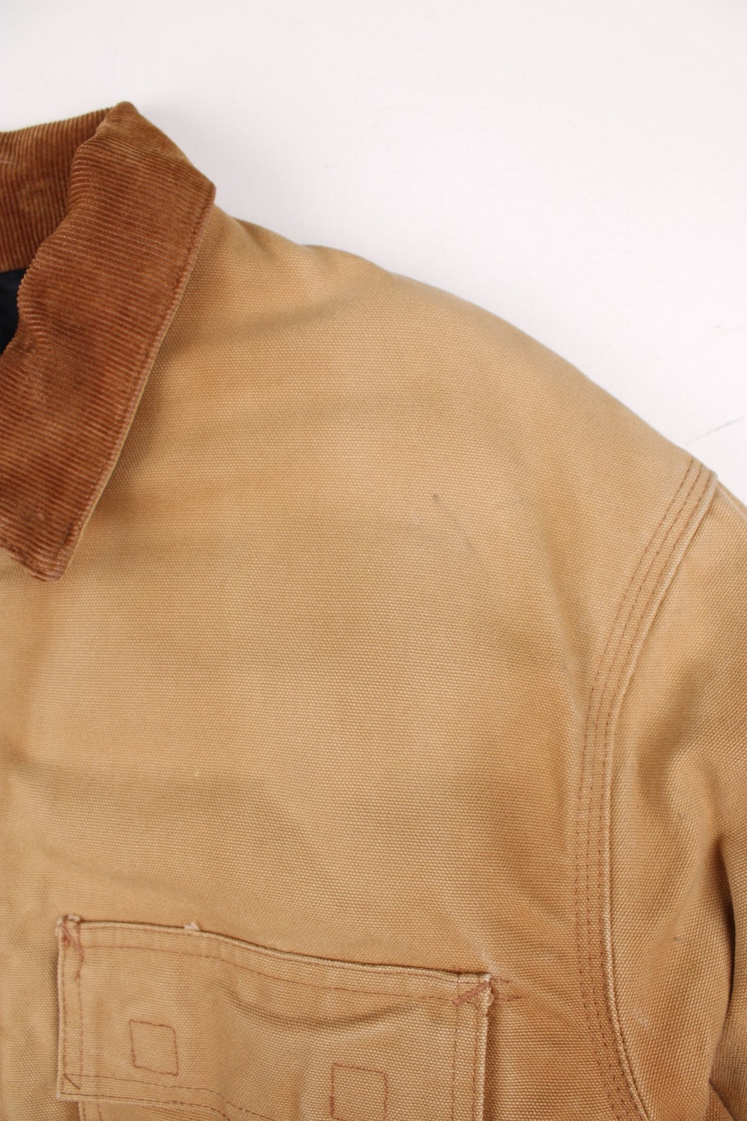 Carhartt Arctic Jacket in a tan colourway. Zips up and has multiple pockets, corduroy collar, insulated with a quilted lining, and has the logo embroidered on the front.