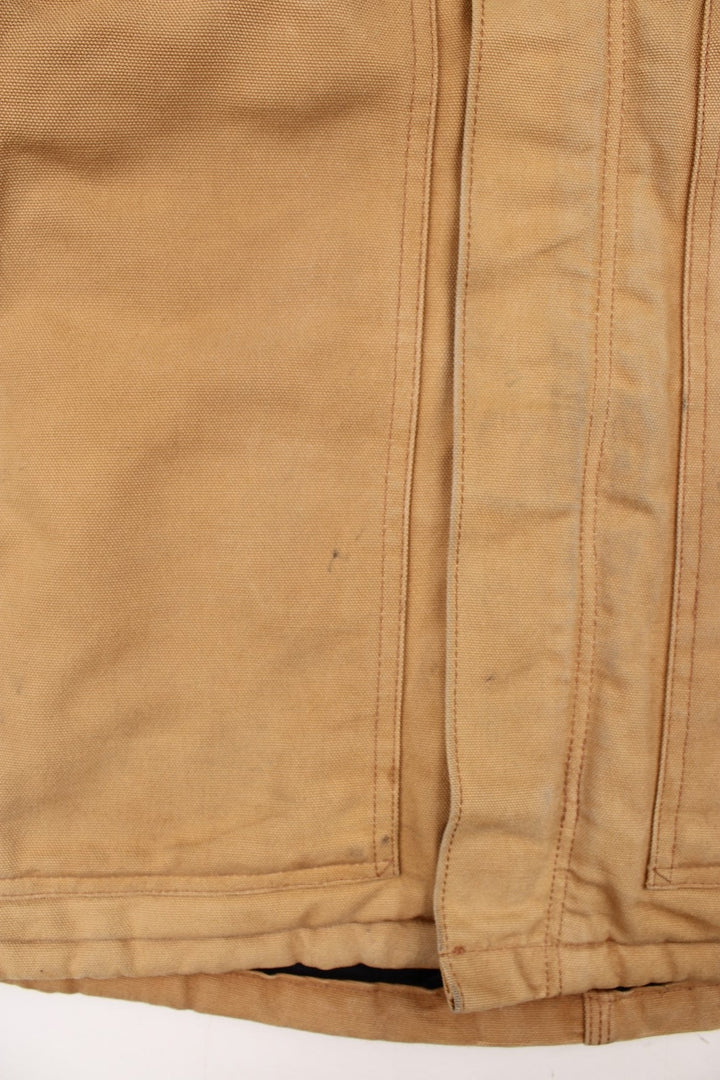 Carhartt Arctic Jacket in a tan colourway. Zips up and has multiple pockets, corduroy collar, insulated with a quilted lining, and has the logo embroidered on the front.