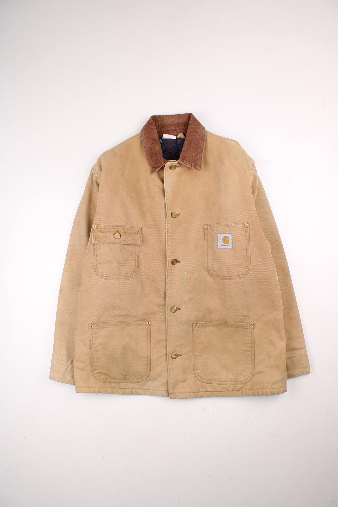 Carhartt Chore Jacket in a tan colourway with a brown corduroy collar. Buttons up and has multiple pockets, blanket lining, and has the logo embroidered on the front.