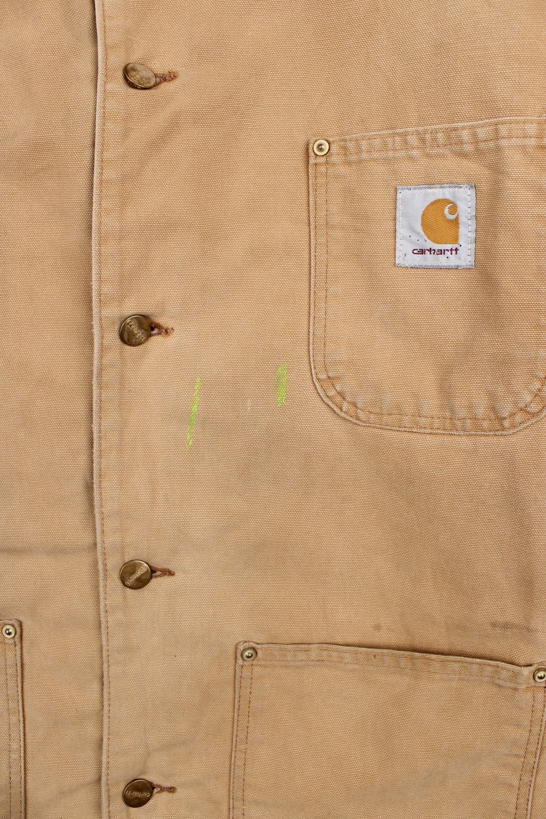 Carhartt Chore Jacket in a tan colourway with a brown corduroy collar. Buttons up and has multiple pockets, blanket lining, and has the logo embroidered on the front.