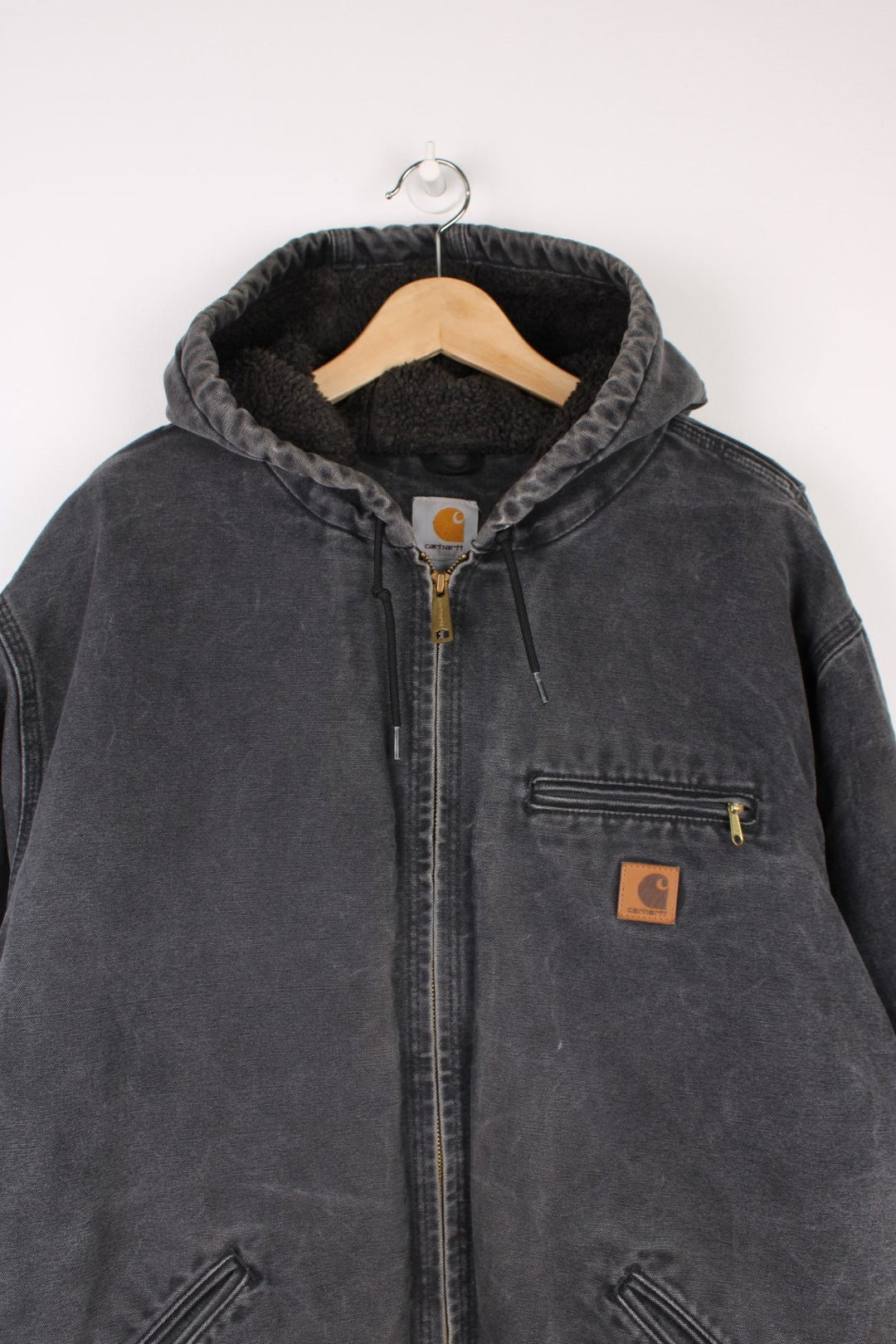 Carhartt Sierra Jacket in a grey colourway, zip up with multiple pockets, sherpa lining, hooded, and has the logo embroidered on the front. 