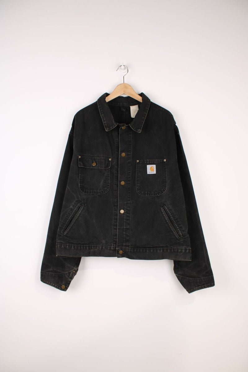 Vintage 90's Carhartt Saledo Denim Jacket in a faded black colourway, button up with multiple pockets, and has the logo embroidered on the front. 