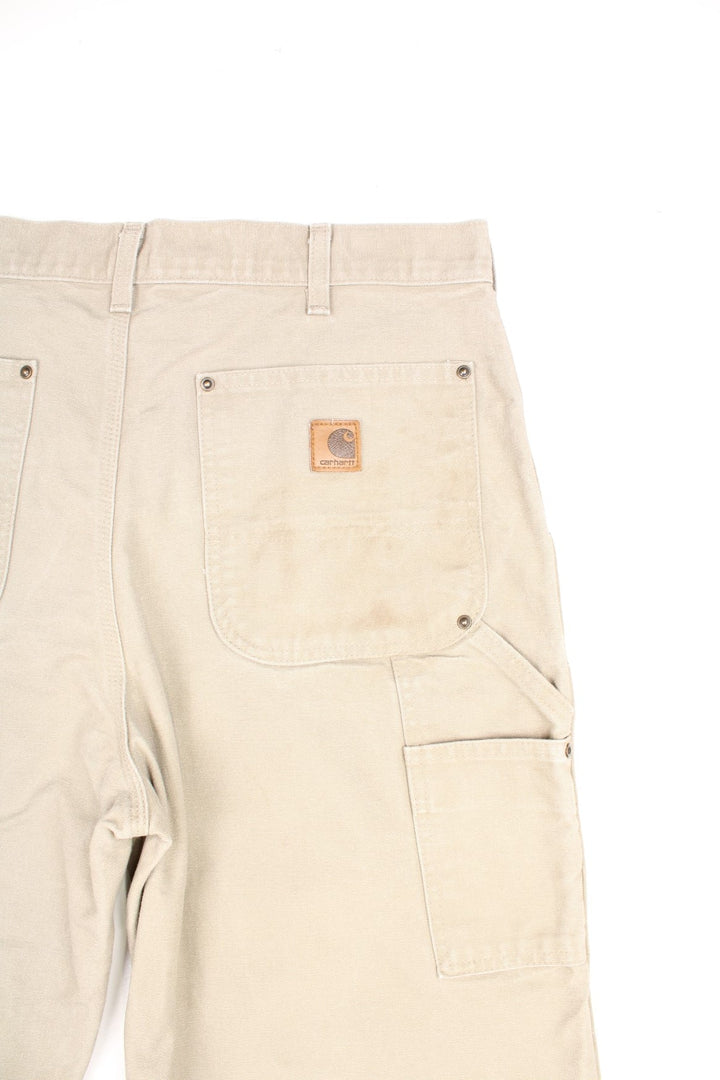 Carhartt tan dungaree fit carpenter jeans. Features double knees, multiple pockets and embroidered logo on the back.