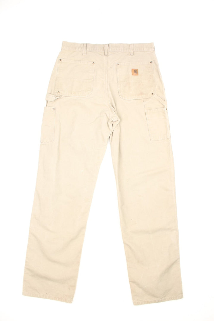 Carhartt tan dungaree fit carpenter jeans. Features double knees, multiple pockets and embroidered logo on the back.