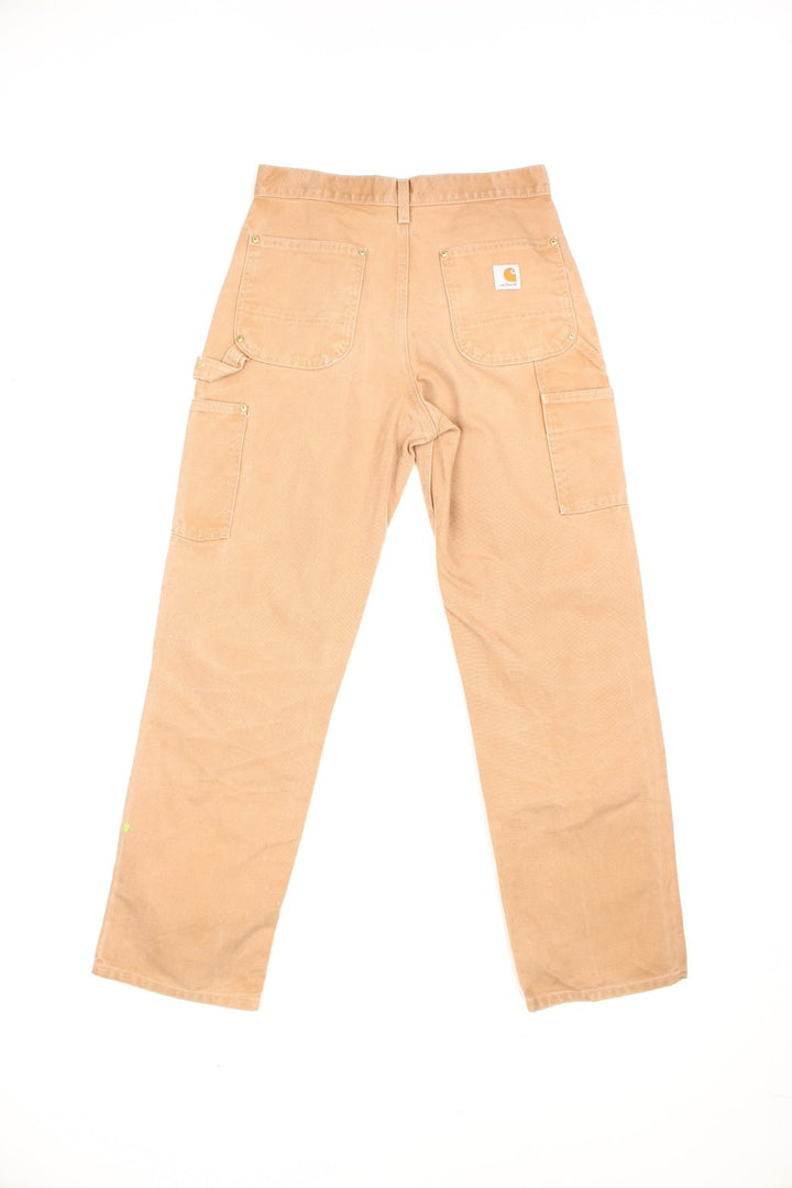 Carhartt brown dungaree fit carpenter jeans. Features double knees, multiple pockets and embroidered logo on the back