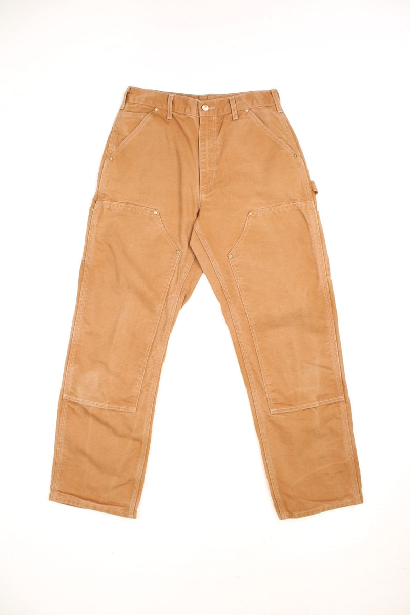 Carhartt brown loose original fit carpenter jeans. Features double knees, multiple pockets and embroidered logo on the back