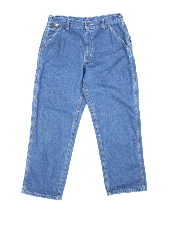 Carhartt Carpenter Jeans in a blue colourway with multiple pockets and the logo embroidered on the back.