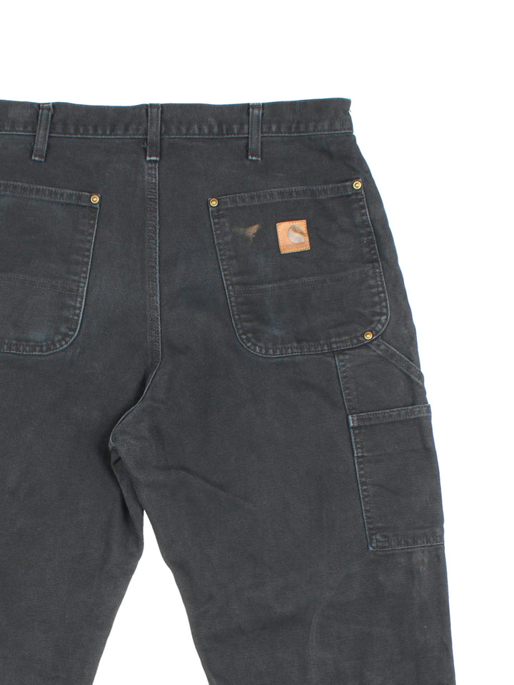 Carhartt Double Knee Jeans in a black colourway with multiple pockets and the logo embroidered on the back.