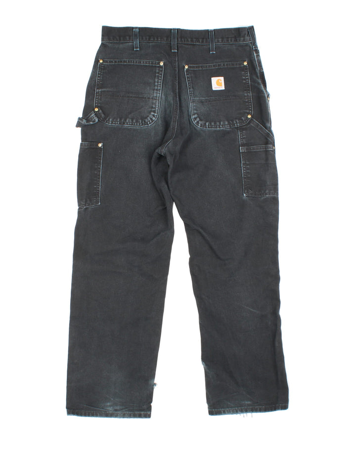 Carhartt Double Knee Jeans in a black colourway with multiple pockets and the logo embroidered on the back.